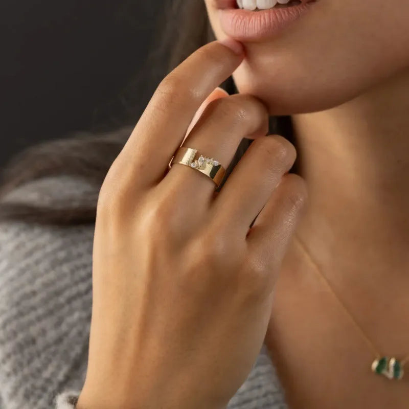 Women's gold-coloured ring with a shining zircon stone on a copper band.