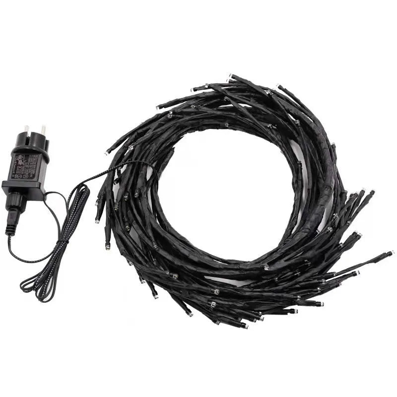 Flexible LED willow vine light garland with warm white bulbs shaped on a wall.