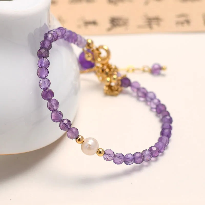 Close-up of a Chinese style women's bracelet with diamond-shaped amethyst crystals and an electroplated finish.