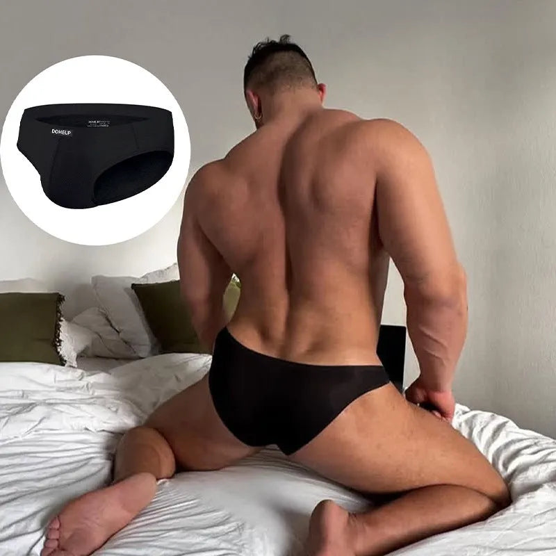 Men's solid colour seamless briefs in black, shown flat, highlighting low waist and knit fabric.