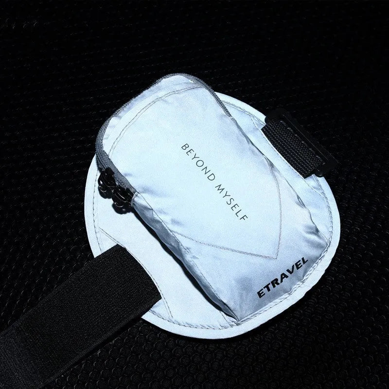 Black reflective running arm band wrapped around an arm, showing its strap and phone compartment.