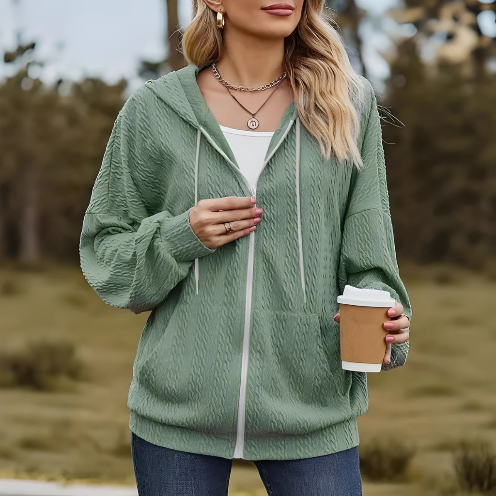 Green women's hooded zipper coat with a loose fit on a hanger.