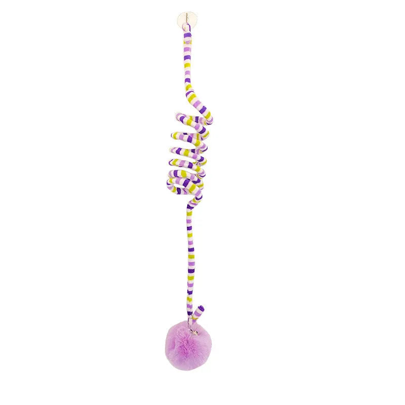 Spring-mounted cat toy with bell stick and inflatable ball, attached to a door via suction cup.
