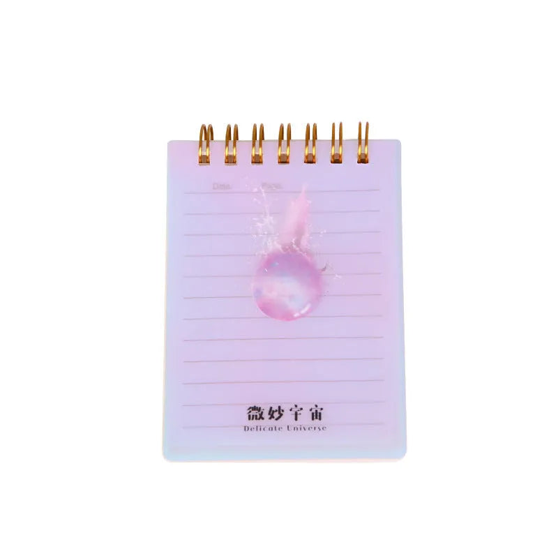 A7 rollover coil pocket notebook with decorative cover, shown with cover folded back to reveal spiral binding and inner pages.