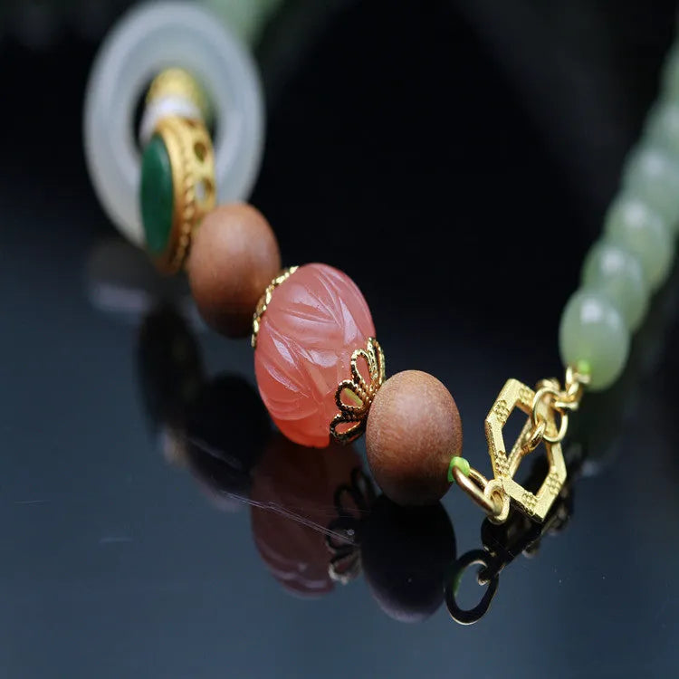 Hetian jade necklace with red lotus beads, white sandalwood, and beeswax, featuring a fu charm and zodiac animal design.