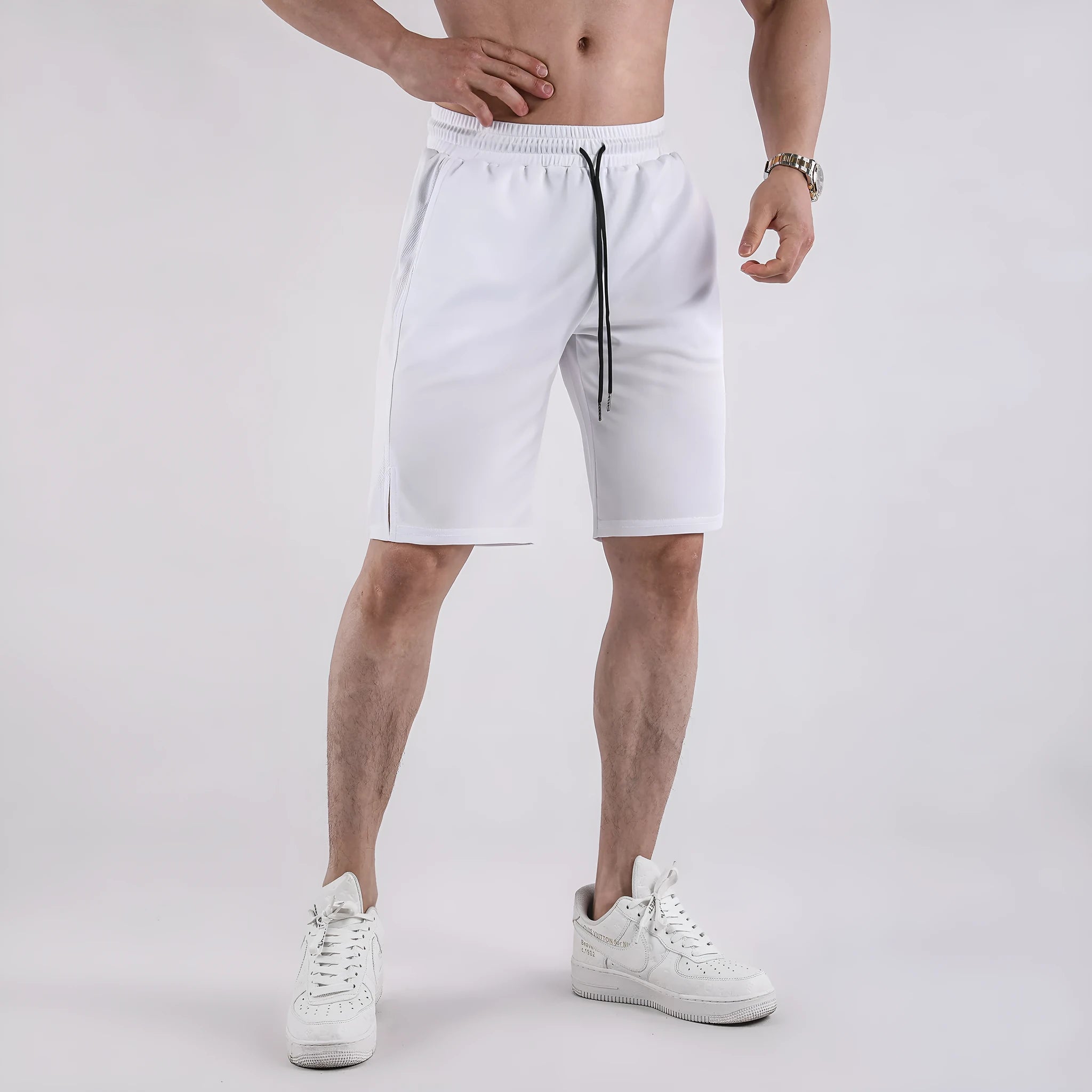 Man wearing loose-fitting black quick-dry mesh fitness shorts with an elasticated waistband.
