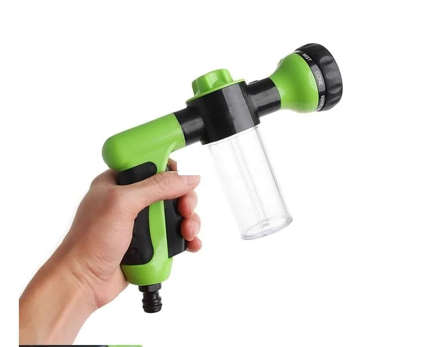 Green high-pressure foam spray gun with adjustable nozzle and connected water hose for car and garden cleaning.