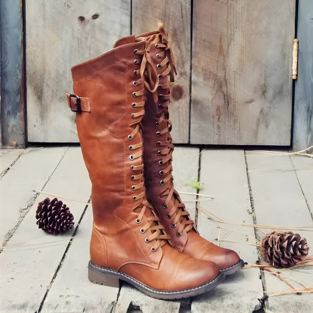 Women's black chunky heel high leg boots with a round toe and low heel on a plain background.