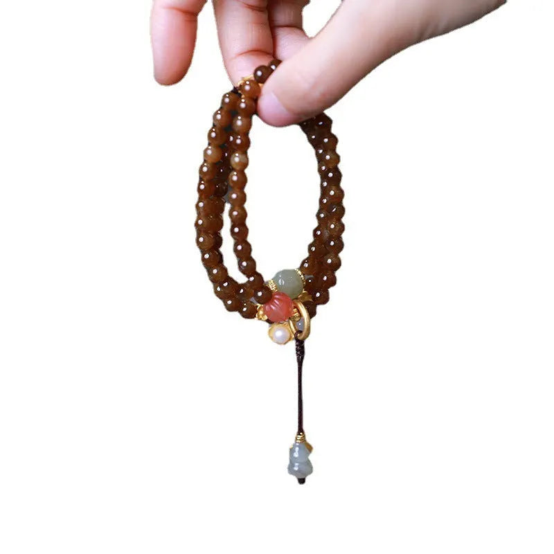 Brown Jade Hetian jade bracelet with butterfly, gourd, and pearl three-ring design and silver-plated fittings.