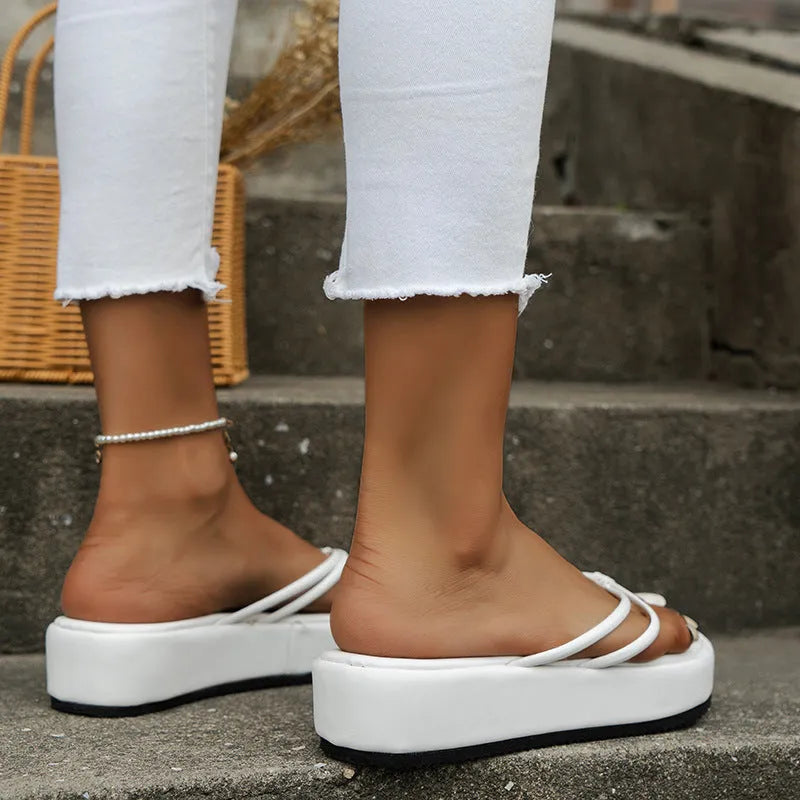 Pair of thick-soled herringbone-patterned flip-flops in blue, showing round toe and rubber sole.