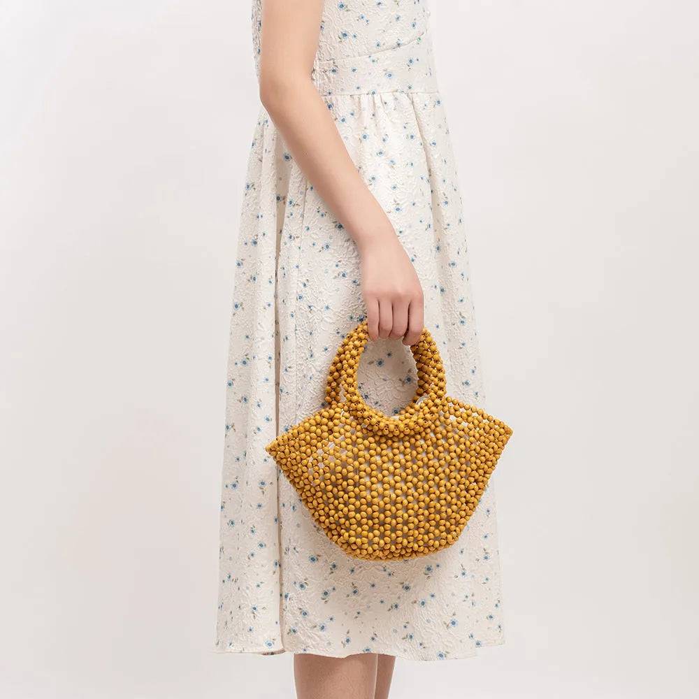 Hand-woven maple beach handbag with wooden beads in dumpling shape, shown in milky white colour