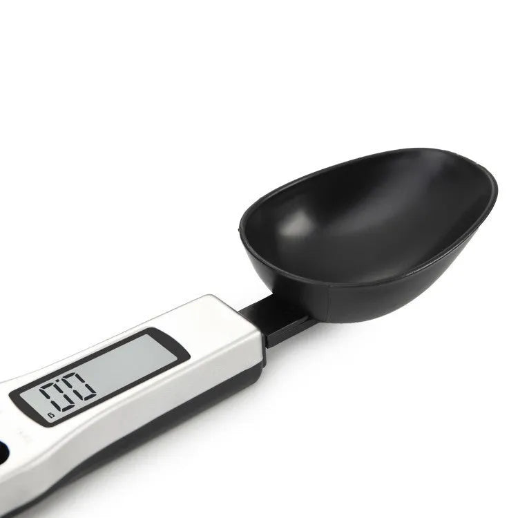 Stainless steel smart digital measuring spoon with a black LCD display showing weight measurement.
