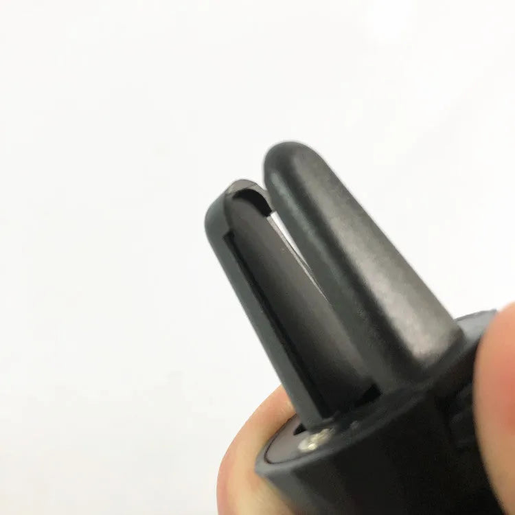 Black car phone holder attached to a car air vent, clamping a smartphone.