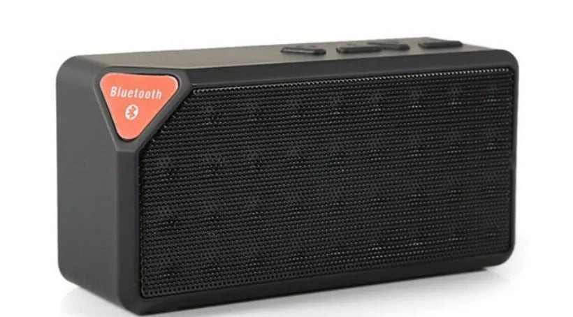 Small cube-shaped Cannon X3 portable Bluetooth speaker in multiple colour options on a table.