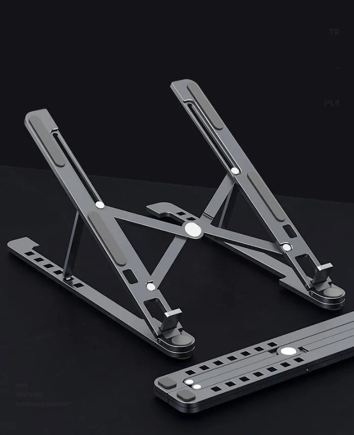 Foldable aluminium laptop stand in silver, shown supporting a laptop at an angle.