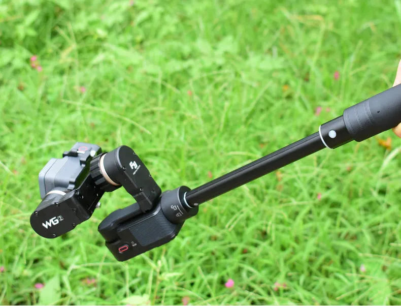 Black retractable selfie stick extended to full length with a smartphone attached, showcasing its hand-held stabiliser grip.