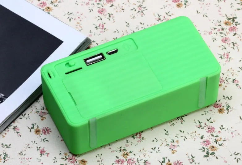 Small cube-shaped Cannon X3 portable Bluetooth speaker in multiple colour options on a table.