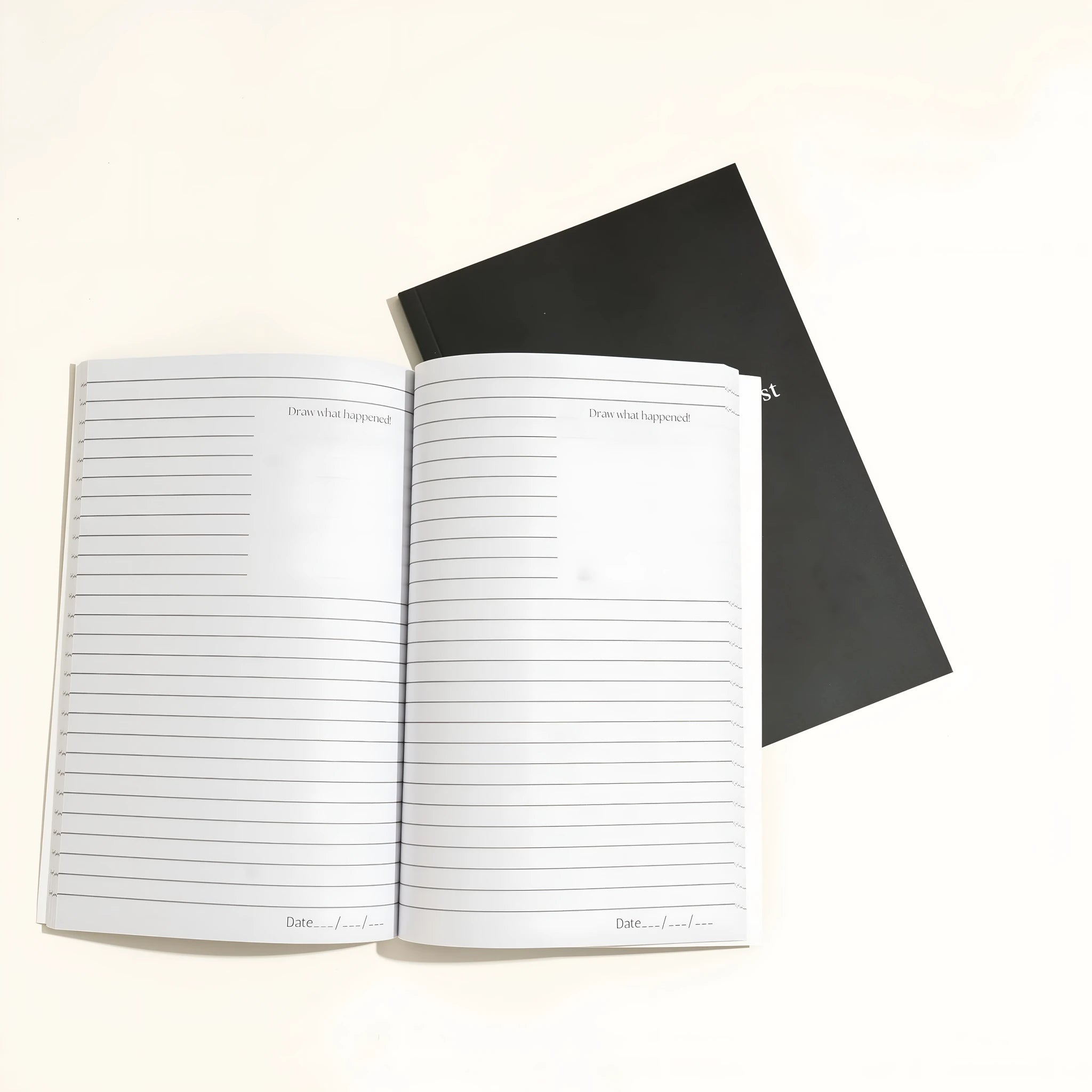 Black A5 hardback dream journal notebook open on a lined page and a dot grid page.