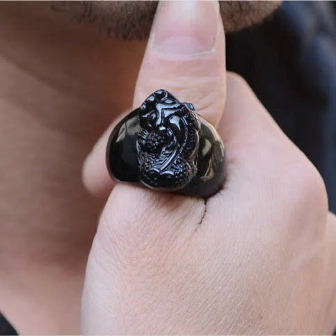 Men's chunky silver thumb ring with a black obsidian crystal showing gold sheen and a detailed Pixiu design.