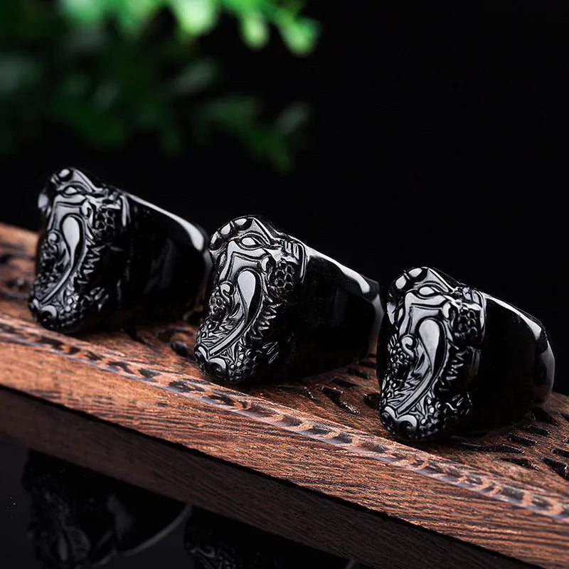 Men's chunky silver thumb ring with a black obsidian crystal showing gold sheen and a detailed Pixiu design.