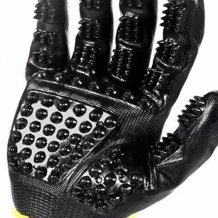 Pet hair grooming glove in black rubber with adjustable wrist strap on a light background