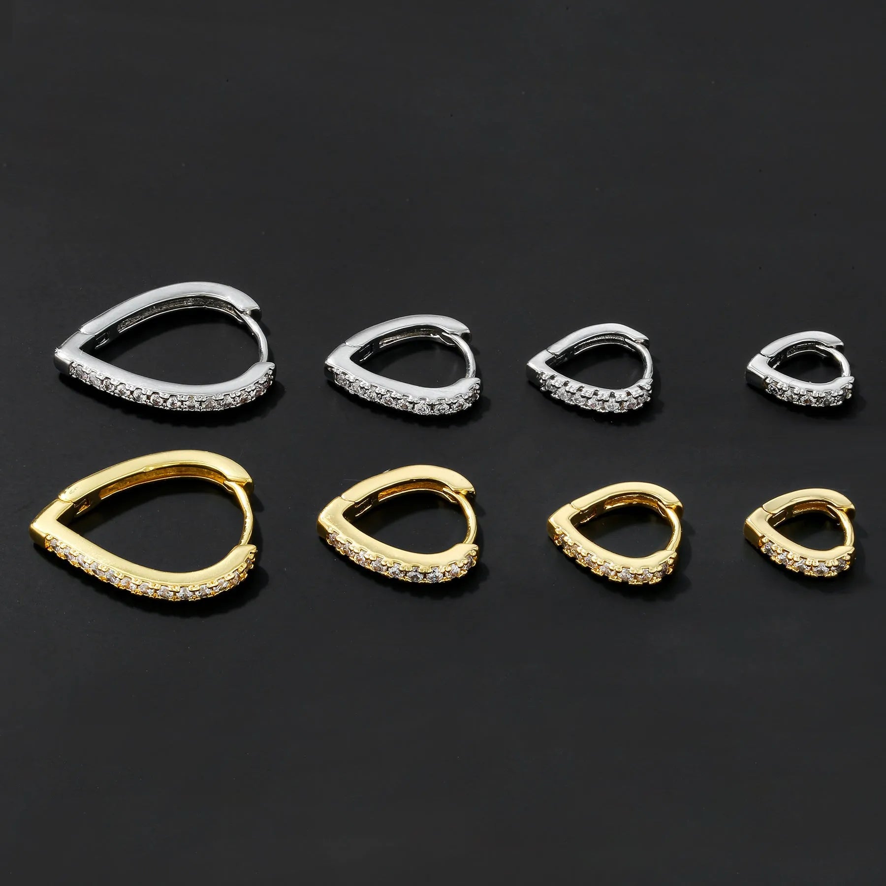 A geometric heart-shaped ear clip in a gold electroplated finish on a copper base.