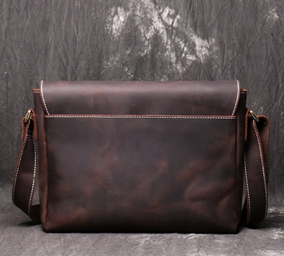 Men's vintage brown cowhide shoulder bag showing medium size and cross-body strap