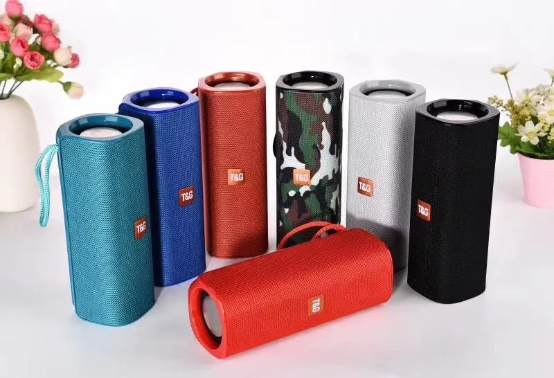 Cloth-covered wireless Bluetooth speaker in multiple colours showing front with speaker grilles