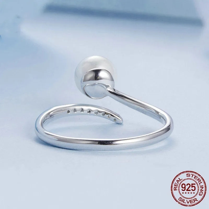 Women's sterling silver adjustable ring with shell pearls on open loop design
