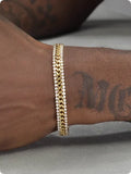 Gold-coloured titanium steel tennis bracelet with artificial gemstone inlay and a clasp.