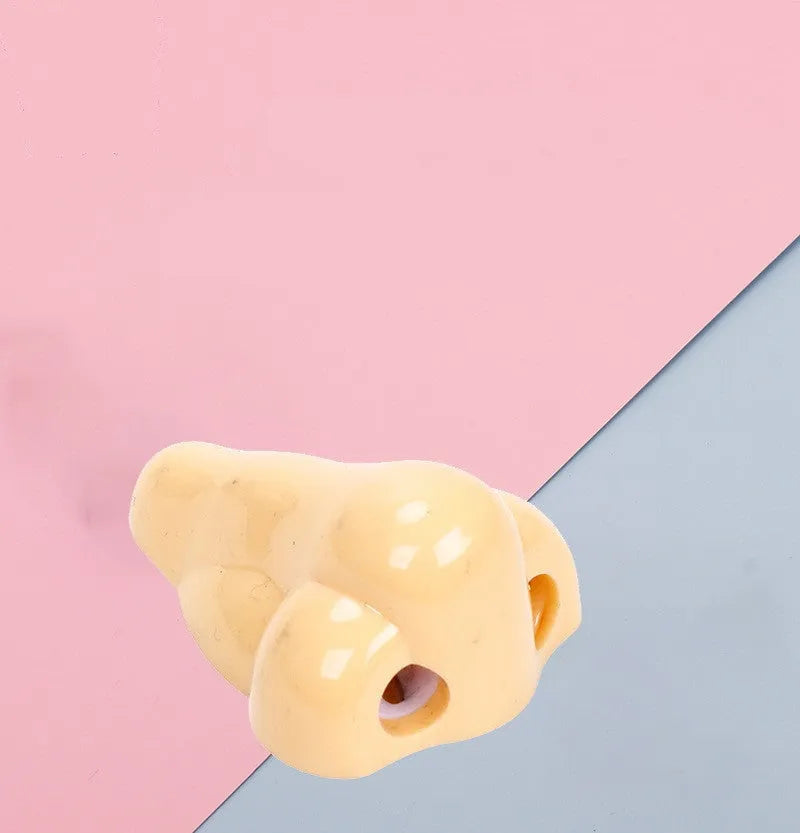 Flesh coloured plastic pencil sharpener with geometry shape on a white background.