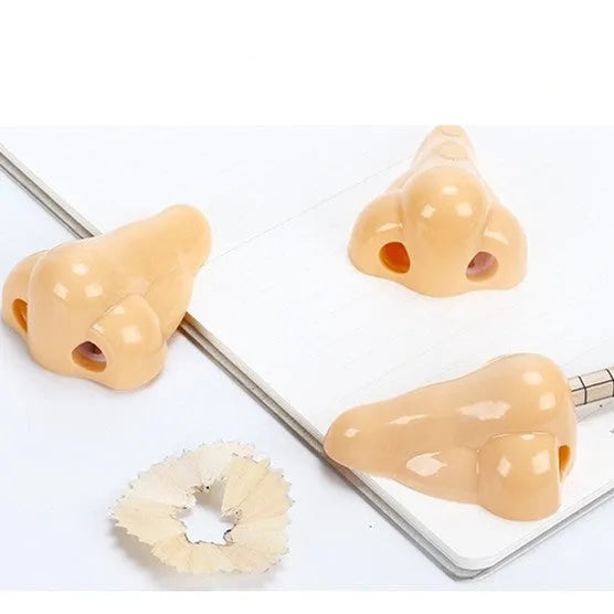 Flesh coloured plastic pencil sharpener with geometry shape on a white background.