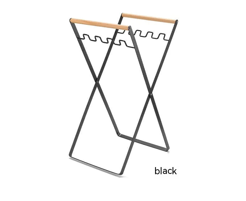 Outdoor black wrought iron garbage storage hanger with wooden handle holding bin bag