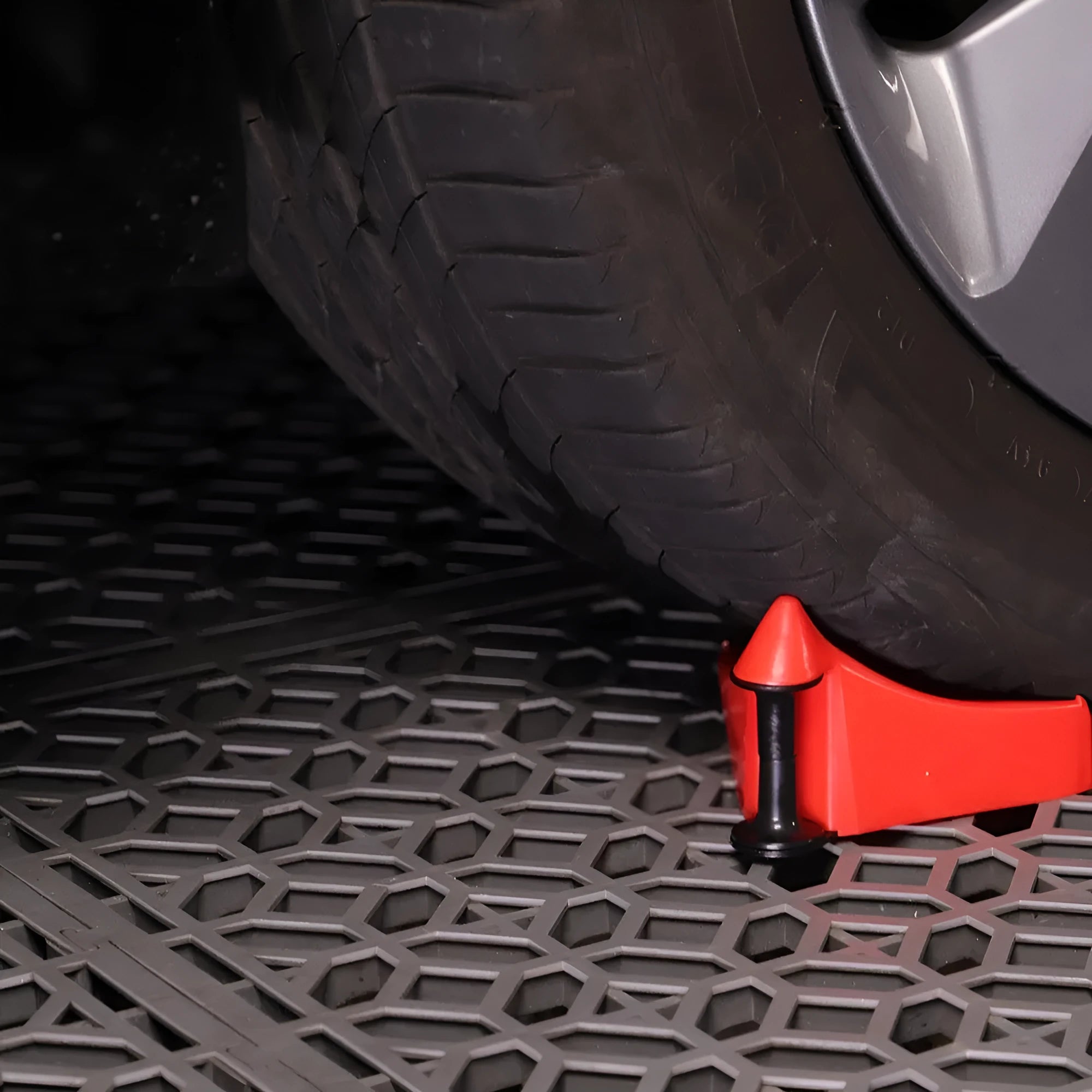 Four bright red triangular plastic parking blocks for car tyres