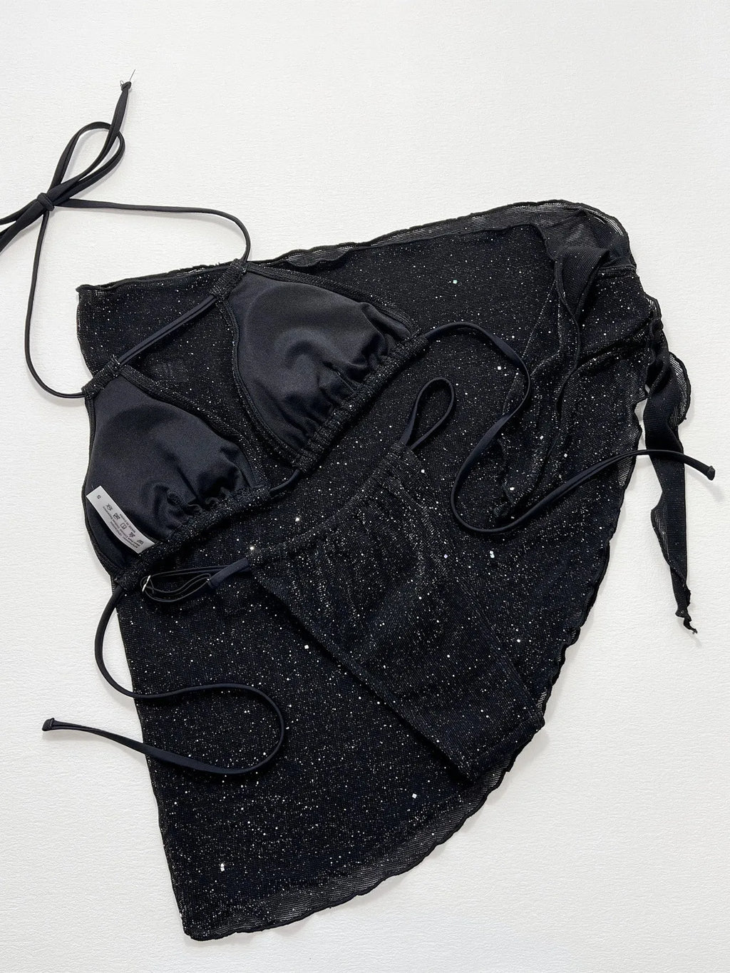 Black three-piece bikini set with triangle top and high-waisted shorts on swimwear model