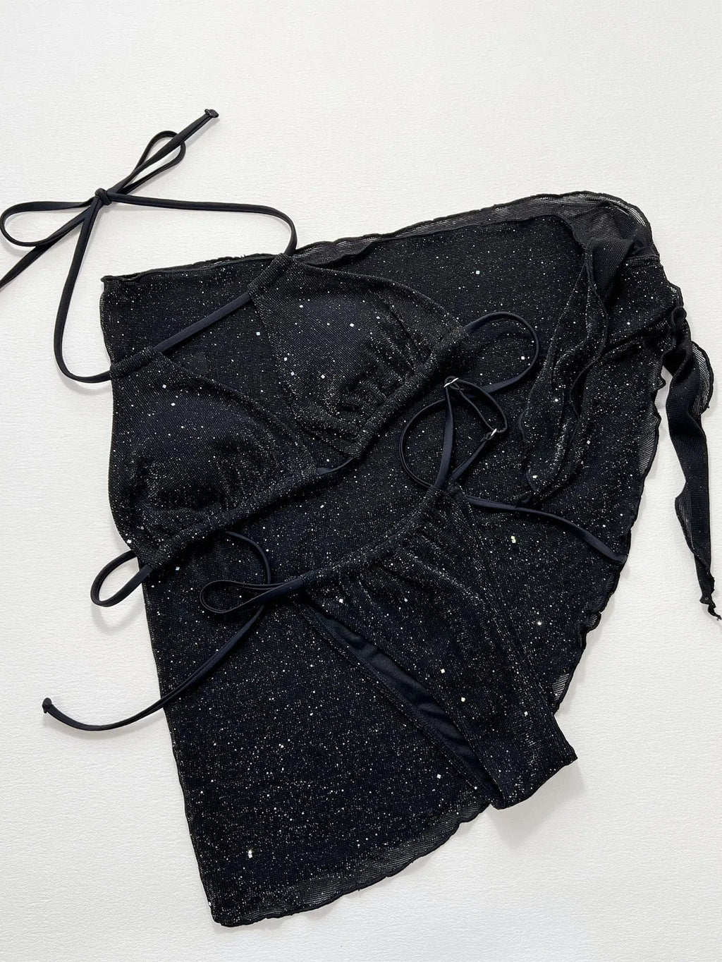 Black three-piece bikini set with triangle top and high-waisted shorts on swimwear model