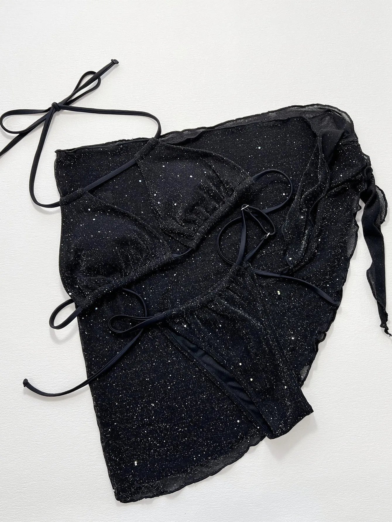 Black three-piece bikini set with triangle top and high-waisted shorts on swimwear model