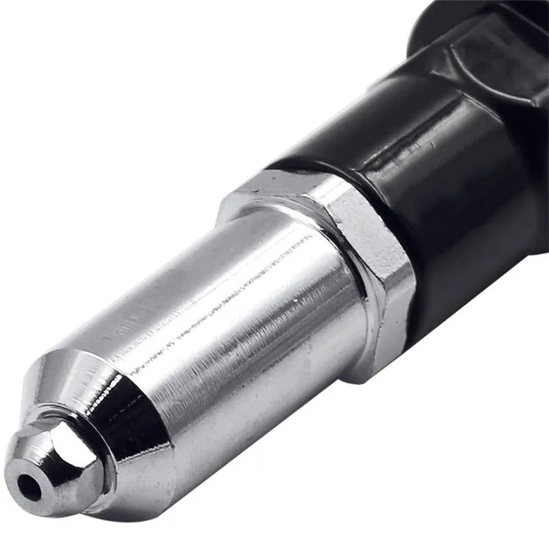 Black metal electric drill rivet gun with wrench and rivet heads on a workbench.