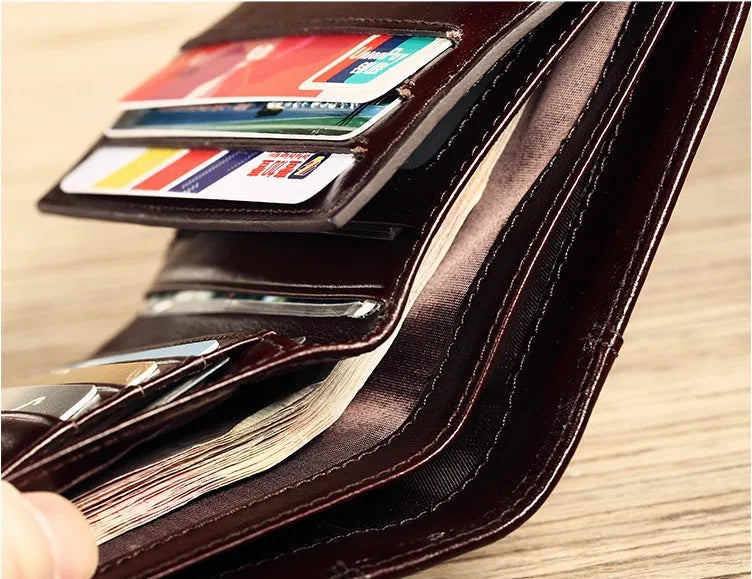 Men's brown leather bifold wallet open to show card slots, coin pocket, and banknote compartment.
