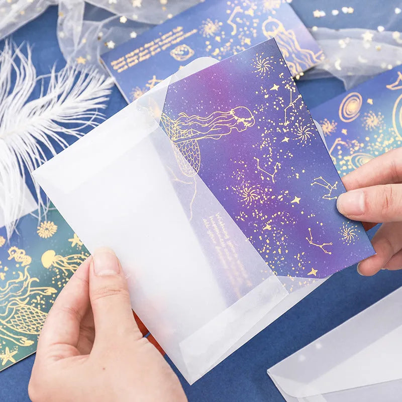 Three decorative paper envelopes with bronzing mermaid design in assorted colours