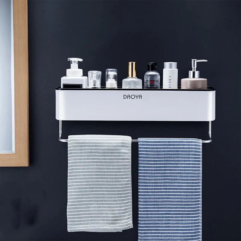 Black adhesive plastic bathroom shelf mounted on a wall holding shampoo and shower gel bottles.