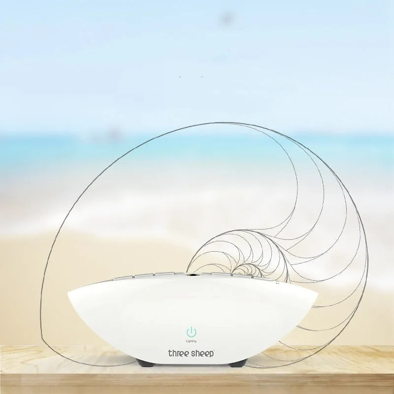 White-coloured white noise sleep aid machine with mechanical control buttons on a bedside table.