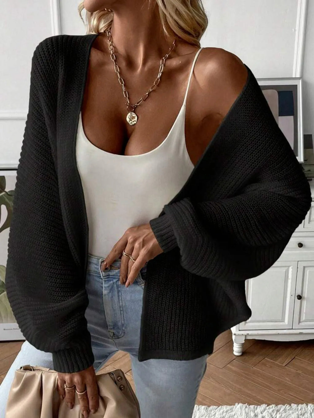Loose-fitting women's cardigan with batwing sleeves in a solid colour, shown on a model.