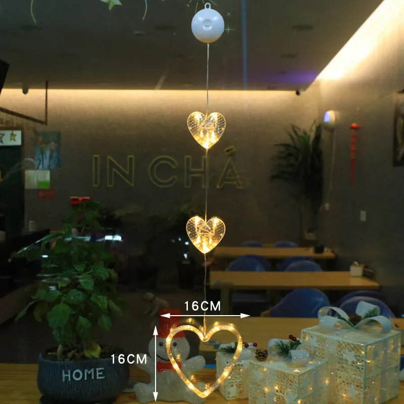 Set of three battery-powered LED Christmas pendant lights with suction cups, showing star, tree, and deer designs.