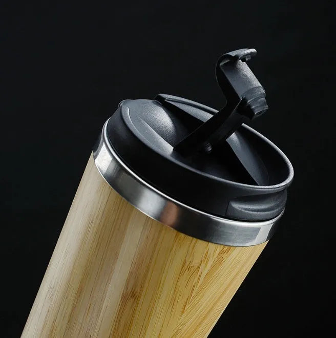 Bamboo travel coffee cup with thermal insulation, leak-proof lid, and 420ml capacity on foam pad