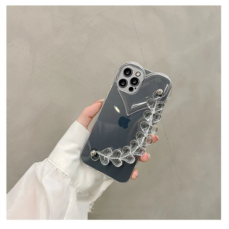 Transparent iPhone case with a love heart charm on a chain, on an iPhone.
