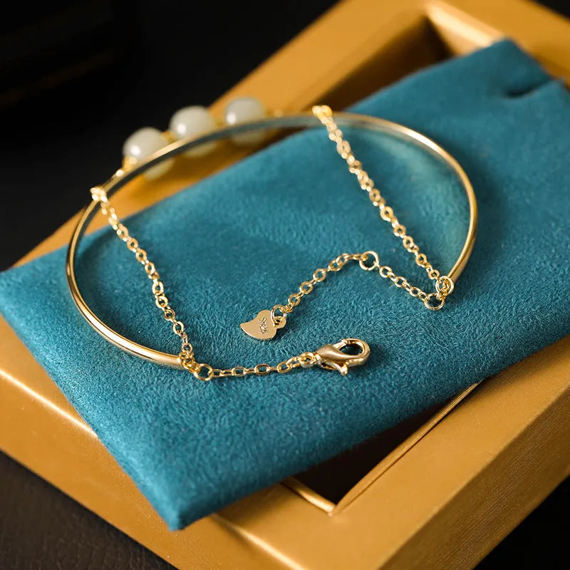 Women's jade bracelet with gold inlay lucky bead design in single, double, or three bead versions.