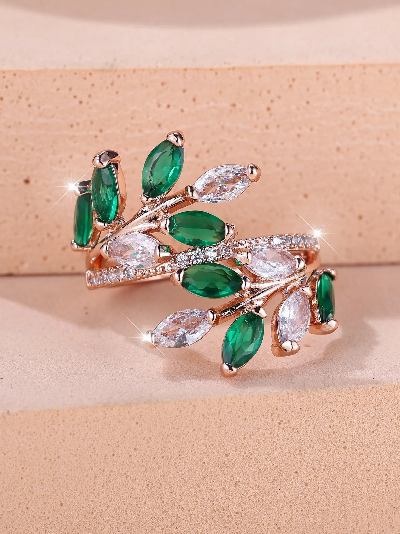 Adjustable open-ended leaf-shaped ring with zirconia stones on a copper band.