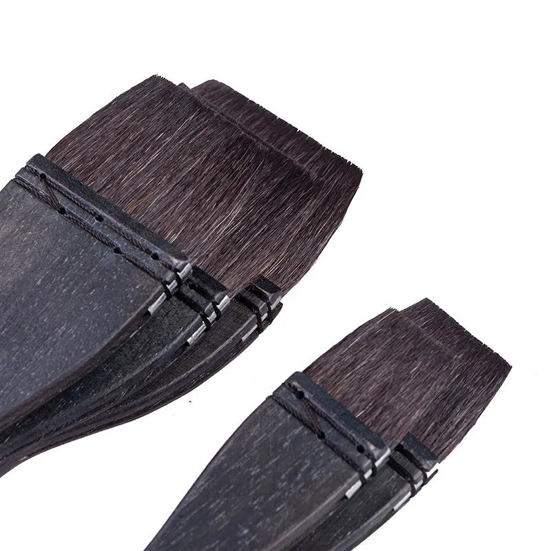 Grey squirrel hair makeup brush with a light wood handle on a plain background.