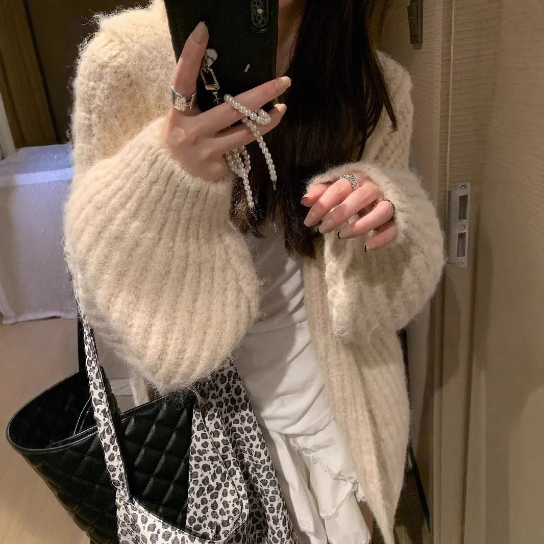 A woman wearing a brown retro-style hooded cardigan with thick knit fabric.